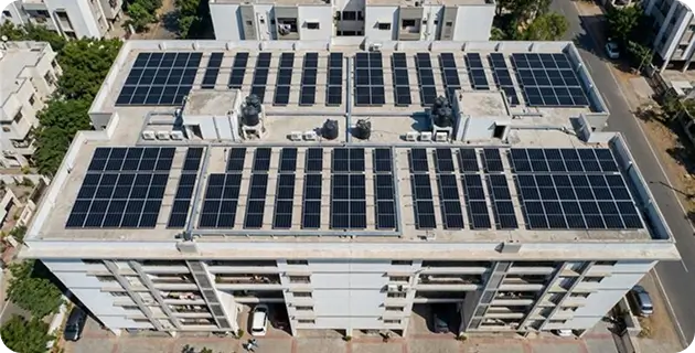 Top aerial view of residential housing society in India with large-scale rooftop solar panel installation for sustainable power generation