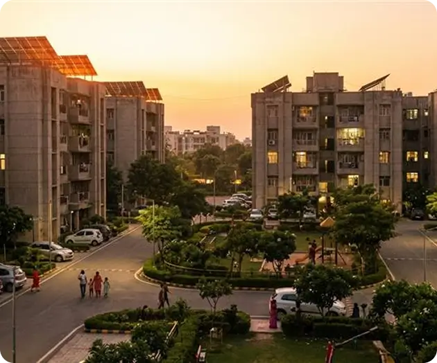 Residential apartment buildings in India with rooftop solar panels installed, evening sunset view with landscaped society courtyard