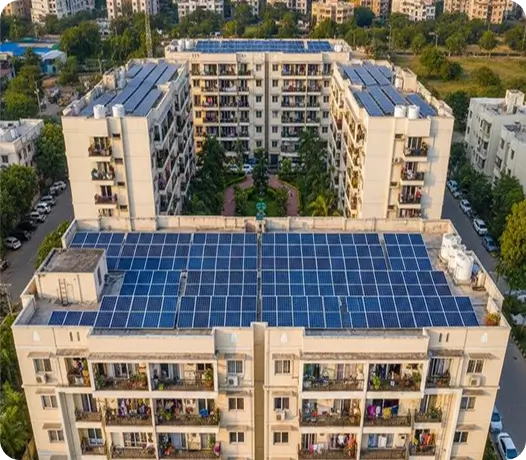 Aerial view of Indian apartment complex with large rooftop solar panel installation for residential electricity generation
