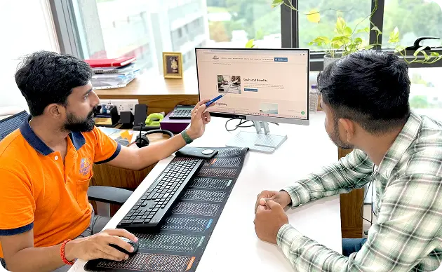 Sunboost Energy consultant explaining solar ROI and system benefits to a customer on a computer in a professional office setting