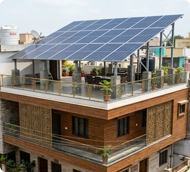 Large rooftop solar panel system installed on a terrace-mounted structure above a modern Indian residential building for maximum solar energy production.